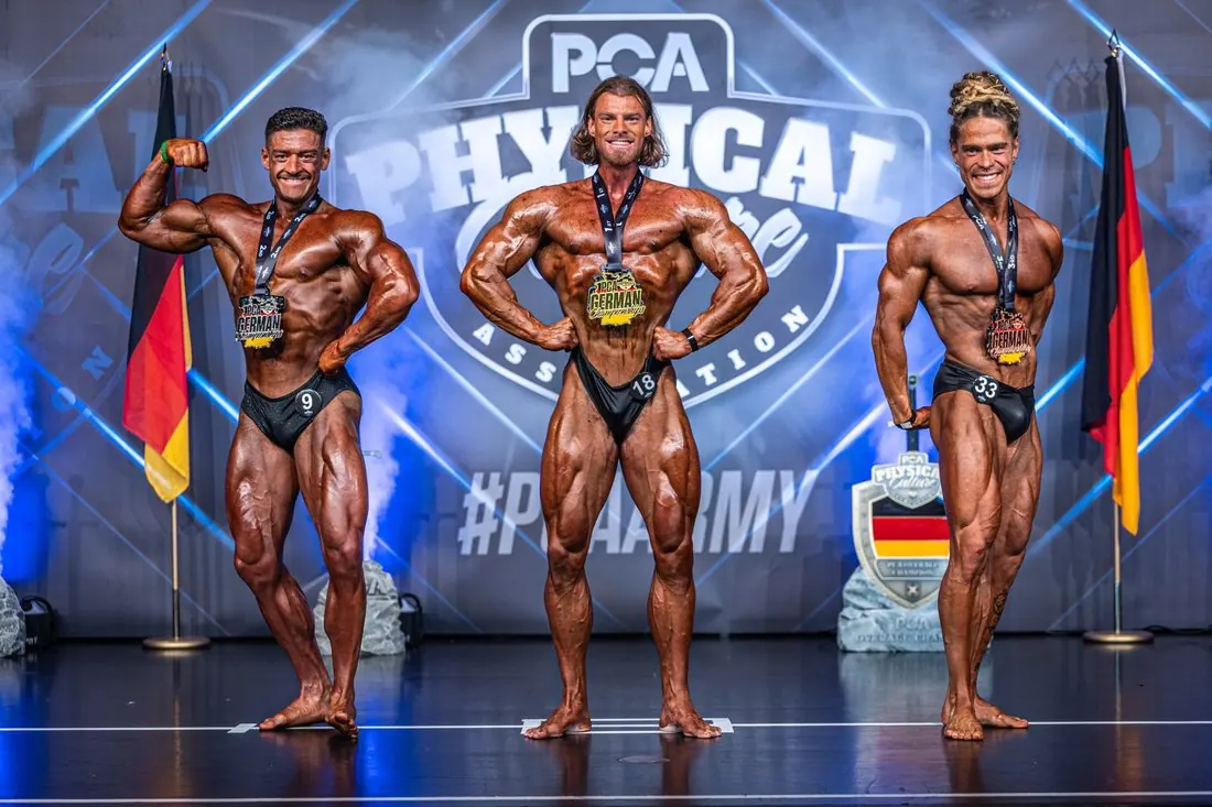 Three medal winners posing on stage